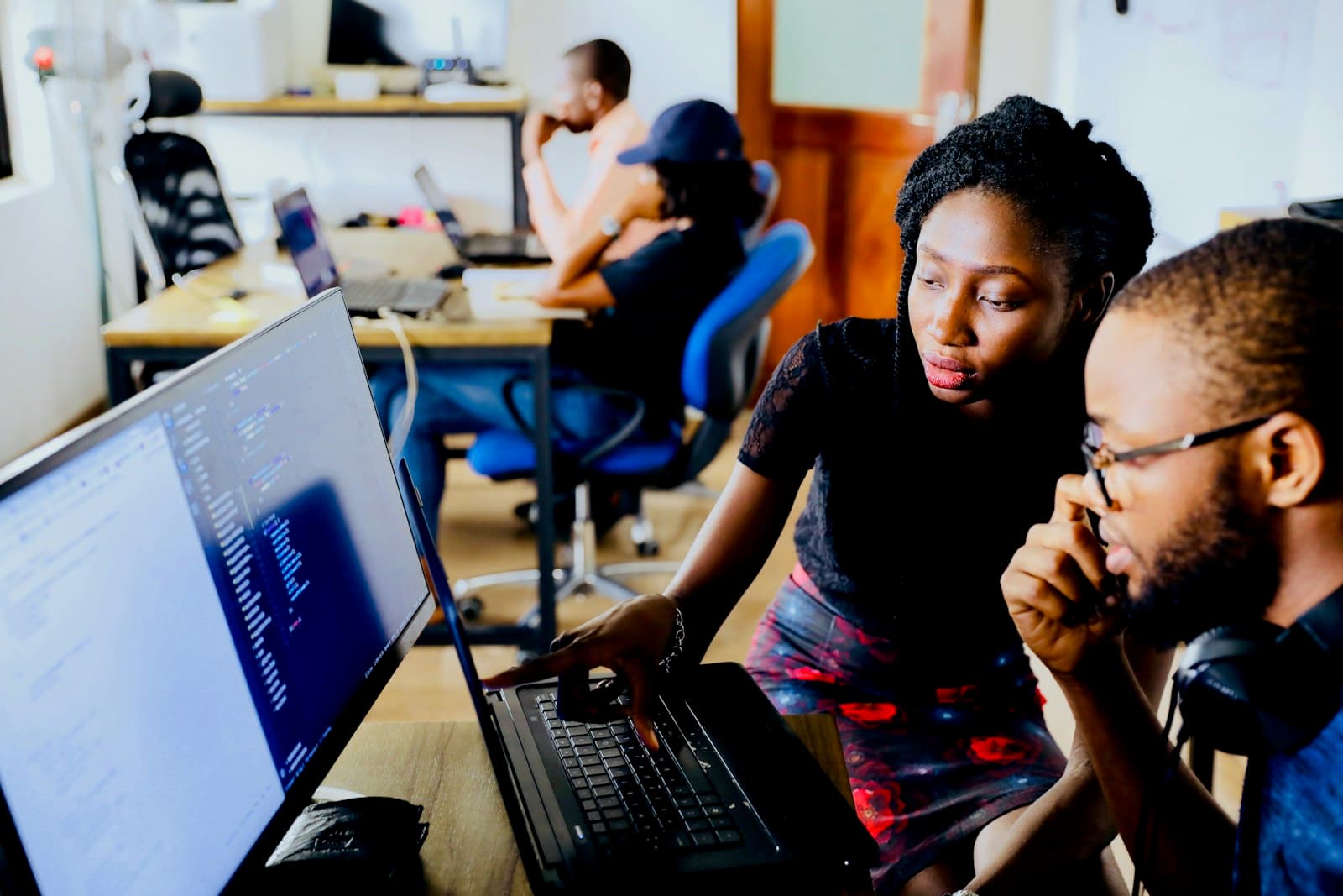 Two people building a product together at a laptop